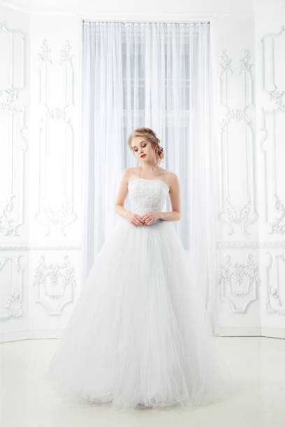 istock A sweet bride in a chic dress in a beautiful light interior. 1153886797