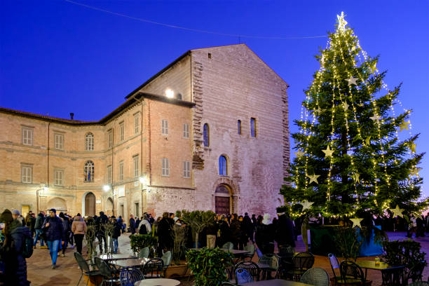 People around the Christmas tree celebrate the religious festivity in Piazza Grande in Gubbio, a town of very ancient origins located in Umbria, central Italy.