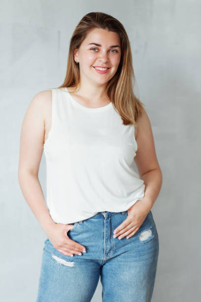 Young beautiful woman in white shirt and jeans Portrait of young beautiful woman in white shirt and jeans plus size woman fashion laughing stock pictures, royalty-free photos & images