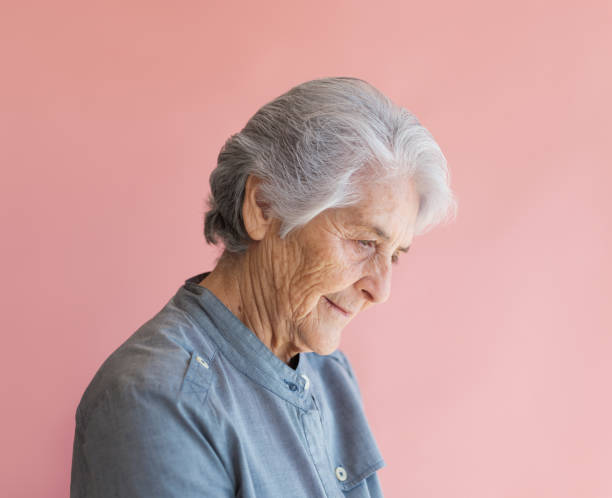 istock Senior woman looking down with a serious expression 1153889303