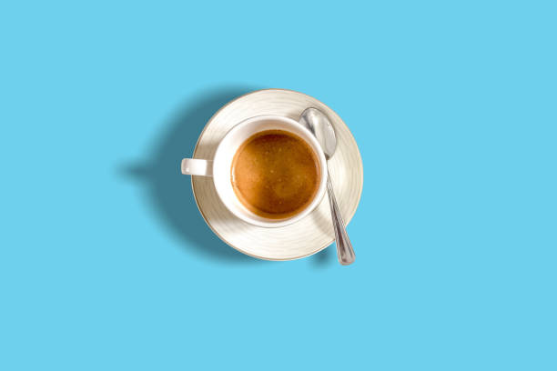 minimalist pattern with a top view of a coffee cup on a light blue pastel table - coffee cup isolated cappuccino multi colored imagens e fotografias de stock