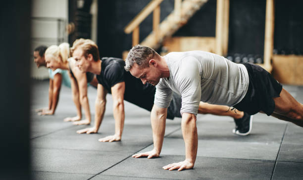 istock Fit people doing pushups together during a gym exercise class 1153889586