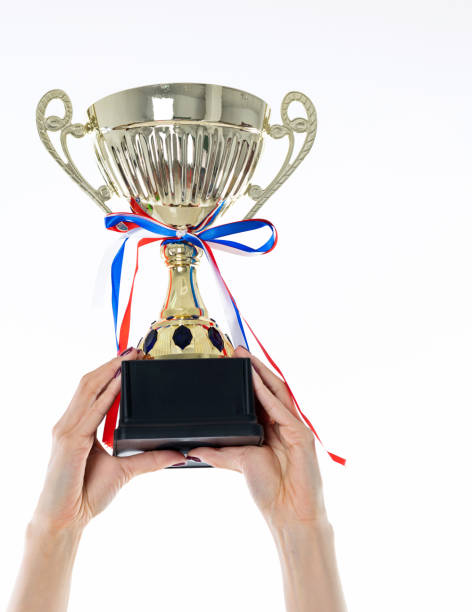 istock Woman hand holding a golden trophy 1153889639
