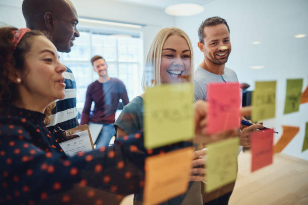 istock Smiling designers brainstorming together on an office wall 1153889740