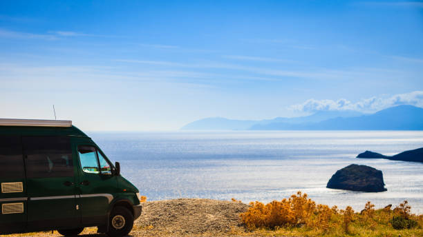 istock Camper car on beach sea shore. Travel 1153890639