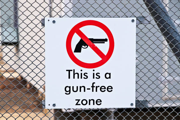 знак зоны, свободной от оружия, на заборе. контроль над огнестрельным оружием в америке концептуальный образ. - gun control стоковые фото и изображения