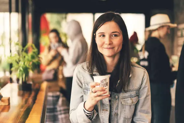 Photo of girl in a coffee shop with a cup of coffee