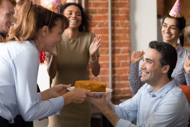 istock Excited team congratulate colleague in office making birthday present 1153894566