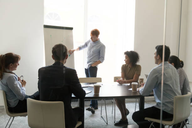 istock Male coach make flipchart presentation for diverse employees 1153894598