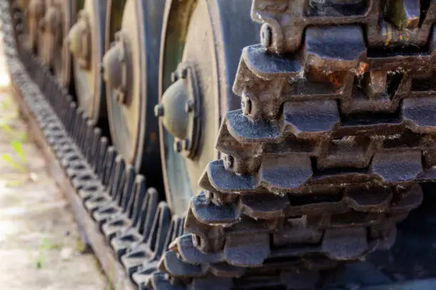 view of the front of the caterpillar tank standing on the ground with wheels close up. Military transportation