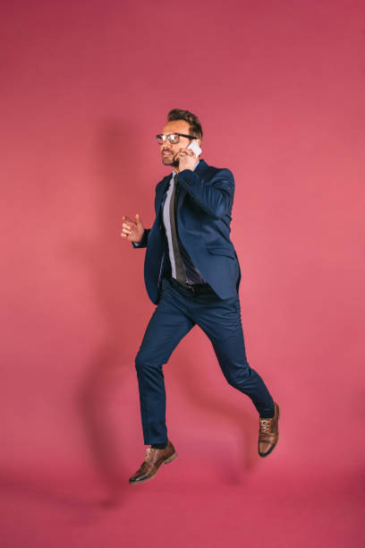 istock Businessman on the mobile phone jumping 1153895275