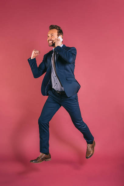 istock Businessman on the mobile phone jumping 1153895283