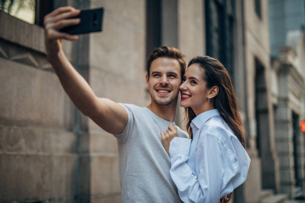 istock Couple standing outdoors and making selfie 1153896748