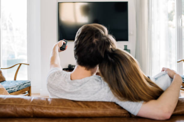 istock Happy couple watching tv 1153900410