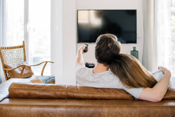 istock Happy couple watching tv 1153900647