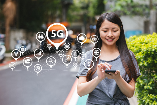 Image of young lady using 5G technology on her smartphone. Mobile communication concept.