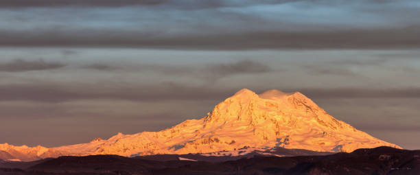 istock Sun setting on snow covered Mt Rainier, Washington 1153906341