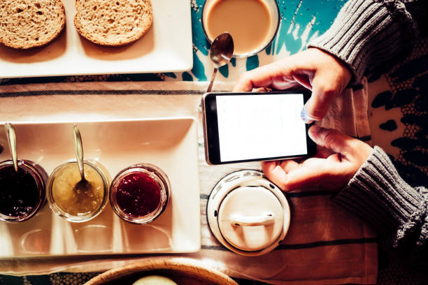 istock Breakfast morning and chat messages with mobile phone - people working with technology or addicted to internet - home or hotel travel lifestyle for modern people 1153907213