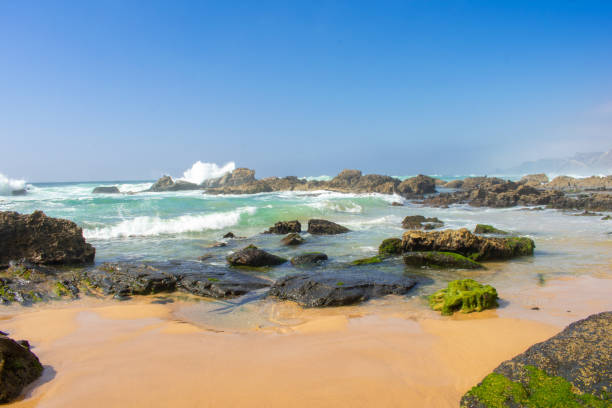 istock Rock formations and cliffs on beach, high waves on water of Atlantic Ocean. West coast of Algarve Portugal 1153908235