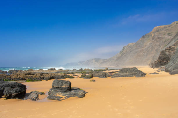 istock Rock formations and cliffs on beach, high waves on water of Atlantic Ocean. West coast of Algarve Portugal 1153908289