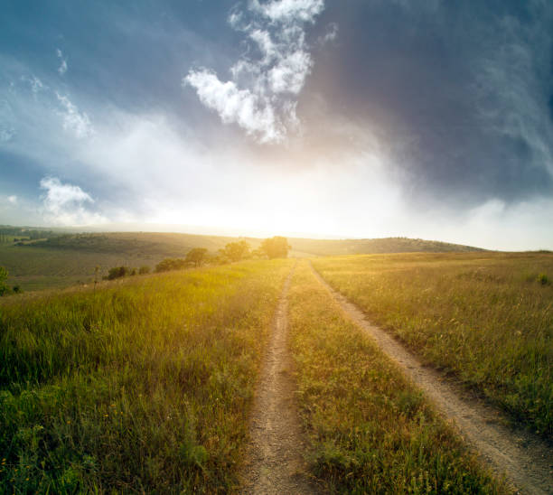 istock red sunset over green field with road 1153915011