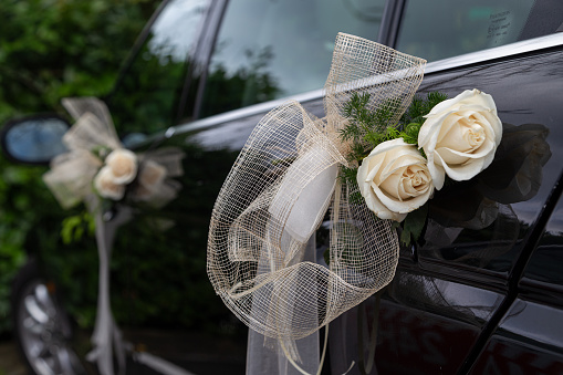 Wedding black car decorated with white roses