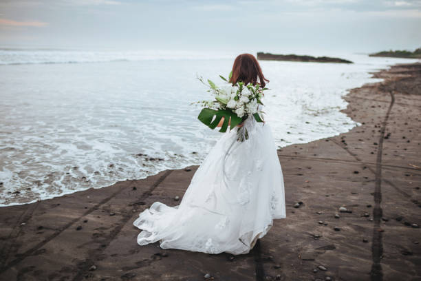 istock Bride on a beach in the blue water 1153919095
