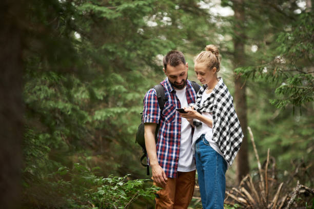 istock Couple with smart phone in the forest 1153921786