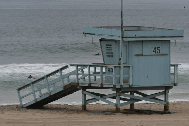 istock Lifeguard Tower with Surfers in the water 1153927654