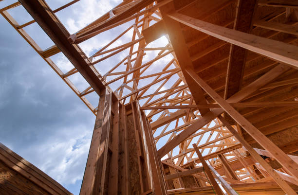 istock Looking up new construction beams under a clear blue sky with sunlight 1153928863
