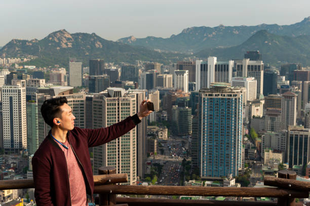 istock Man taking a selfie with the Seoul cityscape 1153931236