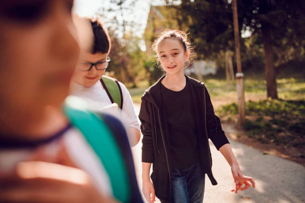 istock Girl walking with friends 1153931951