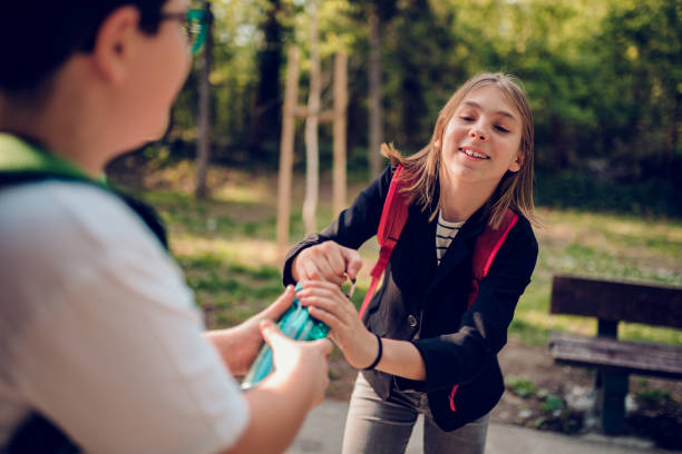 Boy fighting with girl over water bottle at schoolyard Boy fighting with classmate over water bottle at schoolyard schoolyard fight stock pictures, royalty-free photos & images