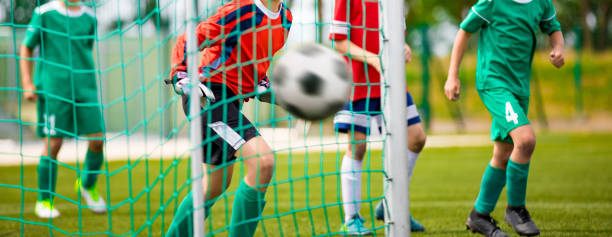 le jeune gardien de but sauve. football fond horizontal. gardien de but junior de football économisant sur un but - playing field kids soccer goalie soccer player photos et images de collection