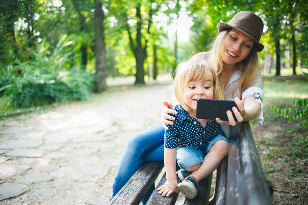 istock Mother and child making selfie in a park 1153943130