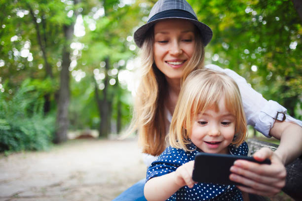 istock Mother and child making selfie in a park 1153943153