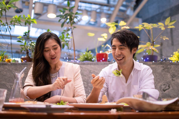 istock Young couple eating salad at restaurant 1153945454
