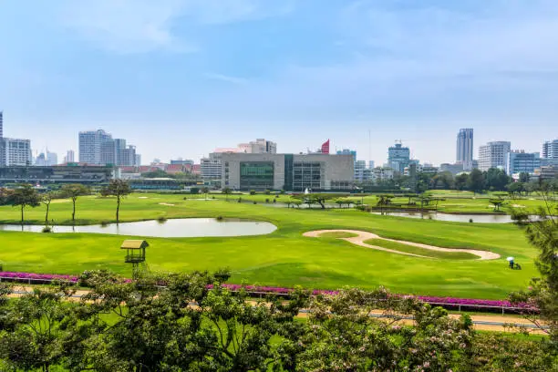 Beautiful green golf course in hart of Bangkok, city skyline in the background, Thailand