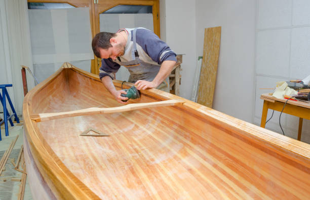 istock Young carpenter making wooden canoes 1153950296