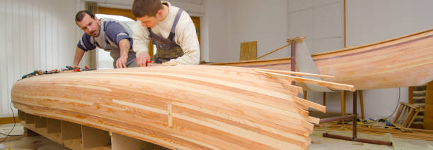 istock Young carpenters assembling new wooden canoe 1153950313