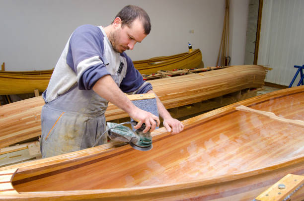 istock Young carpenter making wooden canoes 1153950324