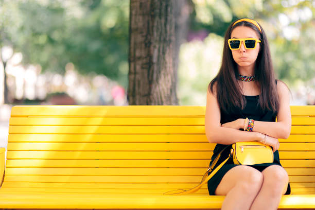 mujer aburrida esperando su cita sola en un banco - pessimist women one person caucasian fotografías e imágenes de stock