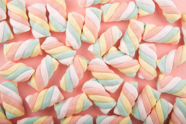 istock Top view on background texture of colorful twisted marshmallow candies. 1153952113