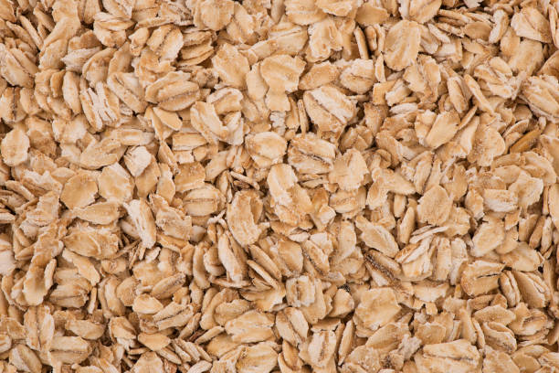 istock Top view on background texture of uncooked oat flakes 1153952123
