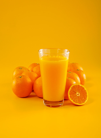 Orange and orange juice on orange background.
