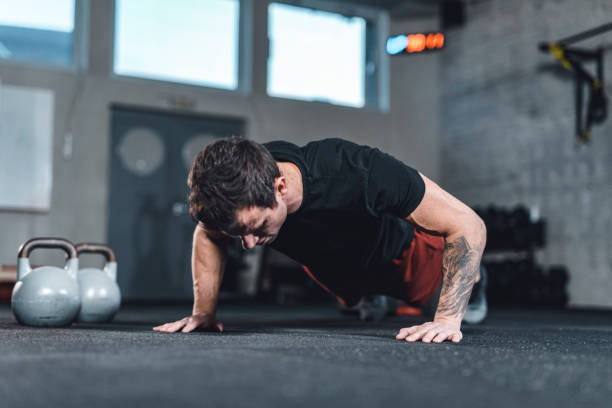 istock Caucasian muscular man doing pushups in the gym 1153954150