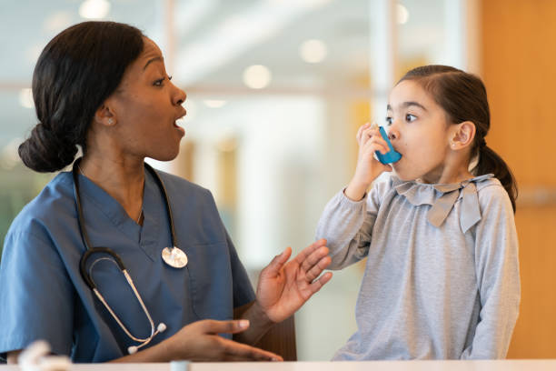 female doctor assists young asthmatic patient - asthmatic imagens e fotografias de stock
