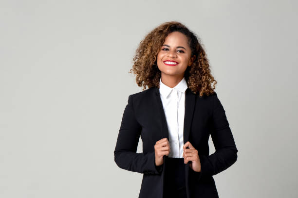 Happy smiling African American woman in formal business attire Happy smiling African American woman in formal business attire isolated on gray background business suit stock pictures, royalty-free photos & images