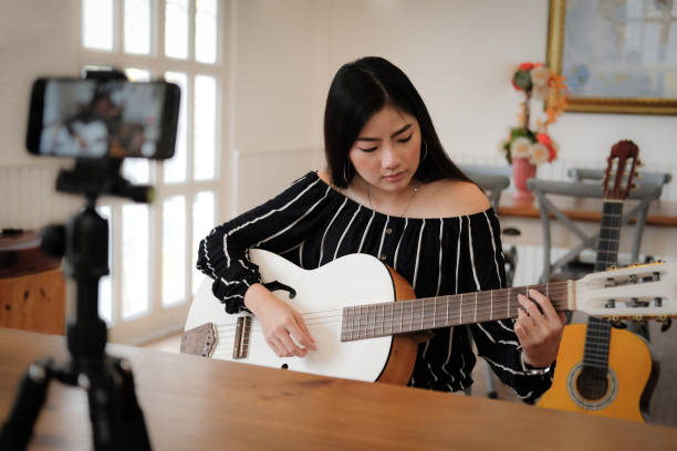 blogger live broadcasting music instrument tutorial on social media. vlogger recording online vlog video.
