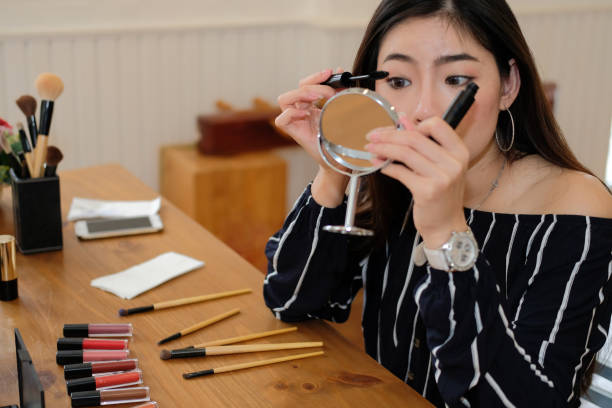 istock asian woman applying makeup cosmetic 1153955947